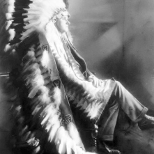 President Calvin Coolidge, wearing a gift, a Sioux headdress.