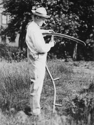 Coolidge sharpening a scythe in order to cut his grass. 