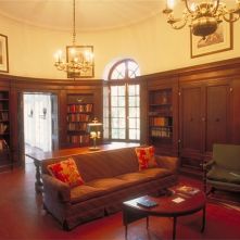 The library where President and Mrs. Coolidge had their portraits painted. The background for the First Lady's portrait is the picturesque Spanish moss and green lawns of this, as with so many, Southern mansions.
