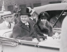 ca. 1925, Pittsburgh, Pennsylvania, USA --- Original caption: Cal Springs the Coolidge Smile for Pittsburgh's Natives. Pittsburgh, Pennsylvania: President and Mrs. Coolidge smile their greetings to the natives of Pittsburgh, Pa., as they parade through the streets as they arrived for the thirty-first Founders' Day celebration at Carnegie Institute. The president made the principal address. --- Image by © Bettmann/CORBIS