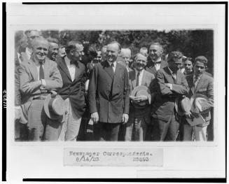 President Coolidge standing with newspaper correspondents on lawn of the White House 8-14-1923