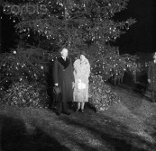 24 Dec 1927, Washington, DC, USA --- 12/24/1927-Washington, DC- Photo shows the President and Mrs. Calvin Coolidge (Mrs. Grace Coolidge), standing in front of the national Christmas tree, lit by the President, officially starting the Christmas holidays in the nation. --- Image by © Bettmann/CORBIS